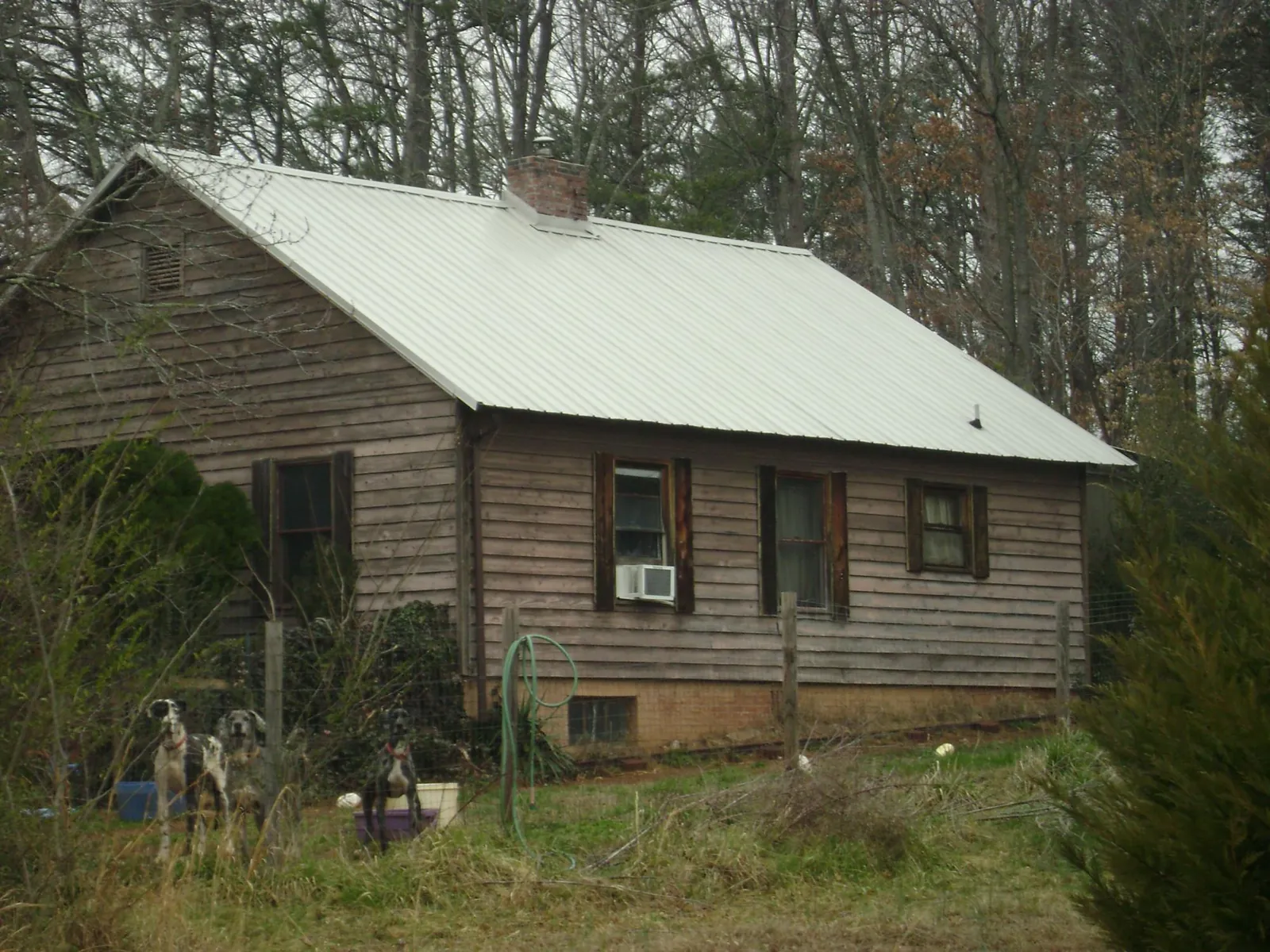 White metal roof on an old wood sided farmhouse, from a Metal Roof Installation job in Smithfield